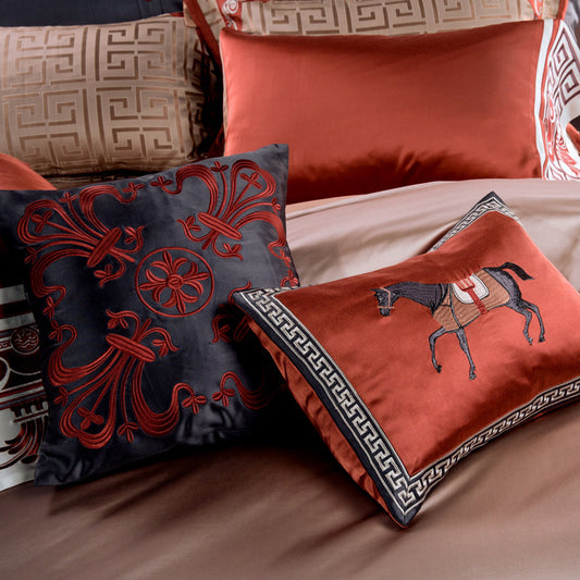 Decorative pillows with intricate designs on a bed