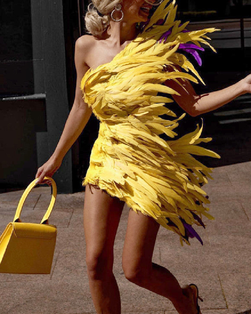 Woman wearing a yellow feathered dress holding a matching yellow handbag.