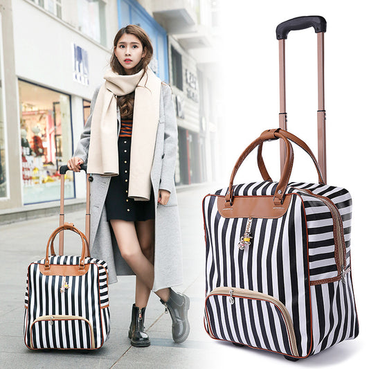 Woman walking with two striped suitcases in a shopping mall.