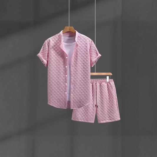 Pink textured shirt and shorts set on a hanger against a dark background