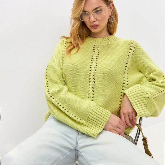 Woman wearing a light green sweater with a white background