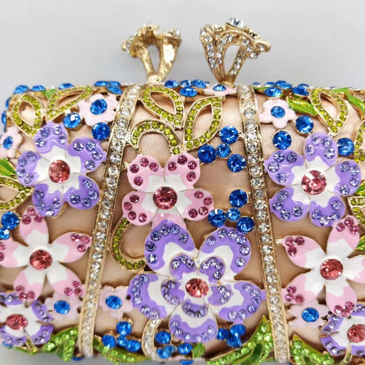 Decorative clutch with floral patterns and colorful gemstones on a light gray background