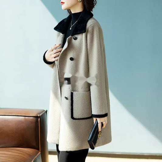 Person wearing a beige coat with black accents in a minimalistic setting