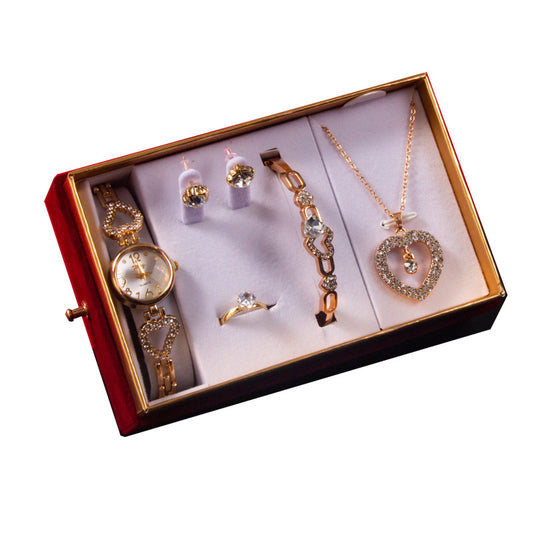 Jewelry set including a watch, bracelet, ring, and necklace in an open jewelry box on a white background.
