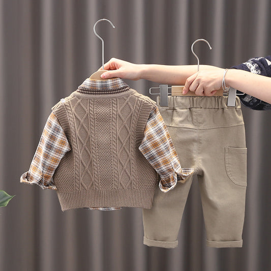 Children's clothing set with sweater and pants on hangers against a neutral background
