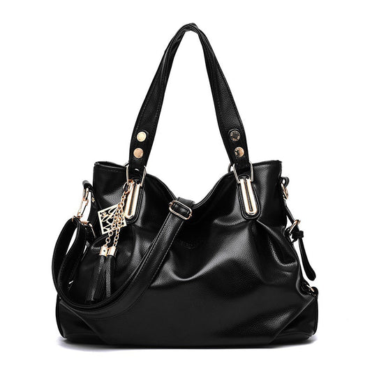 Black handbag with gold accents on a white background