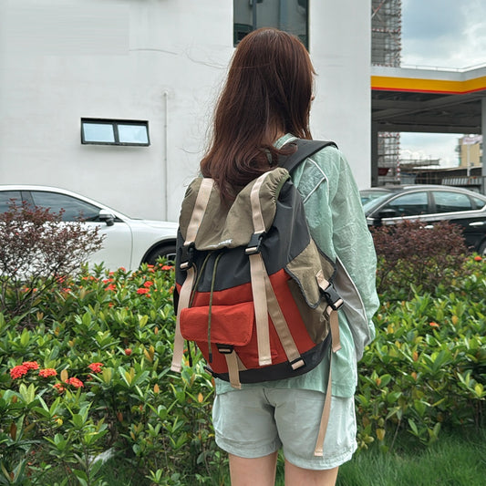 Person with a colorful backpack standing outdoors near a building