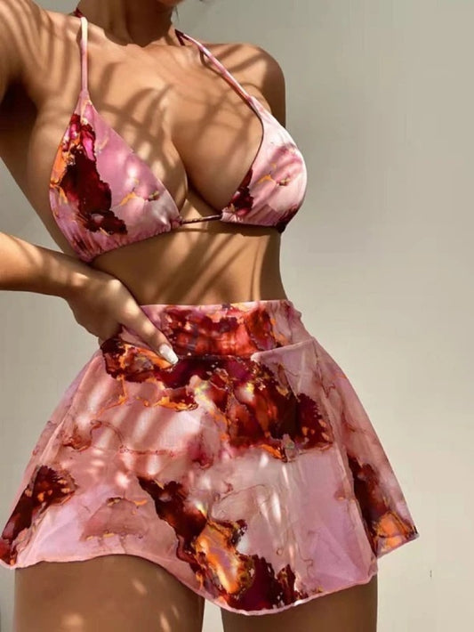 Person wearing a pink and red patterned bikini set against a neutral background