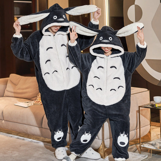 Two people wearing black and white animal-themed onesies in a living room.