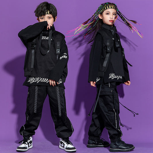 Two children wearing black outfits with visible branding against a purple background