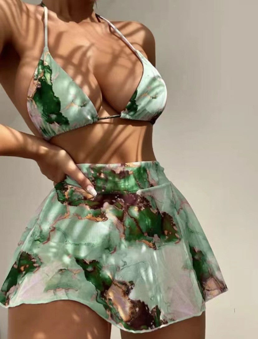 Green and pink floral two-piece swimsuit on a neutral background