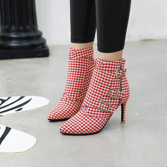 Red and white checkered high-heeled boots with buckles on a light gray floor.