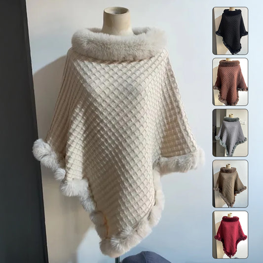 Knitted poncho with fur trim on a mannequin against a light background
