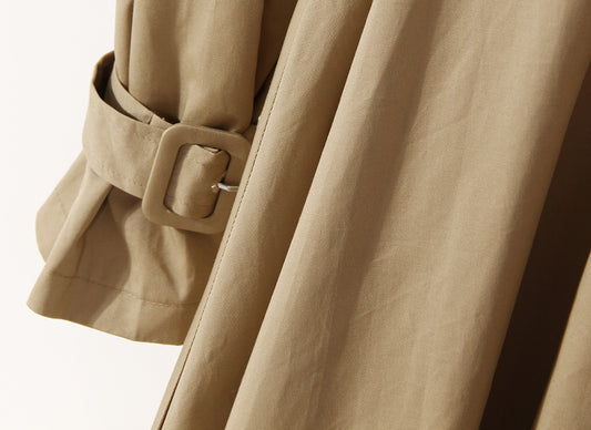 Close-up of a beige trench coat with a belt and buckle on a light background by millivan