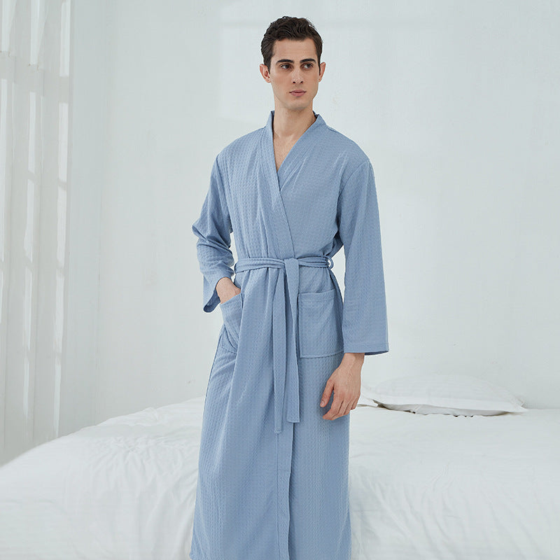 Man wearing a light blue robe in a bedroom setting