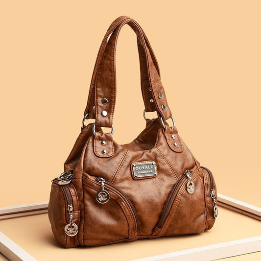 Brown leather handbag with visible brand logo on a beige background