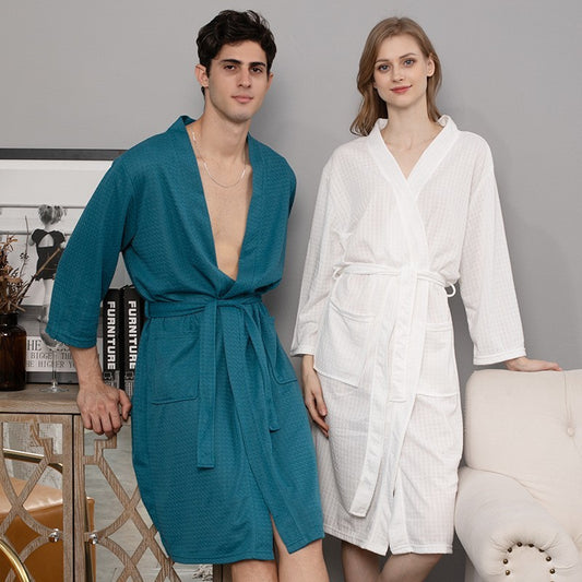 Man and woman wearing teal and white robes in a room setting.