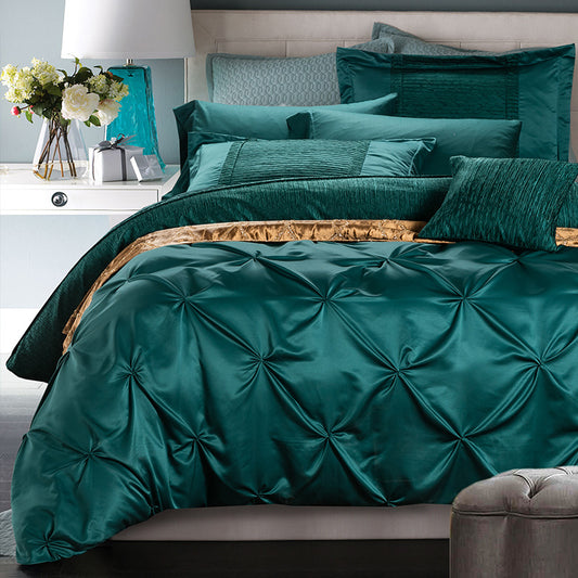Teal bedding set on a bed with decorative pillows and flowers in the background.
