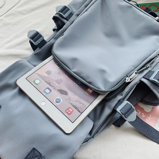 Gray backpack with a tablet inside on a light-colored surface