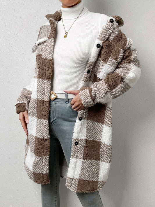 Person wearing a checkered brown and white coat on a plain background