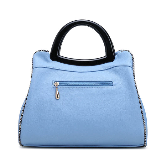 Light blue handbag with a black handle on a white background