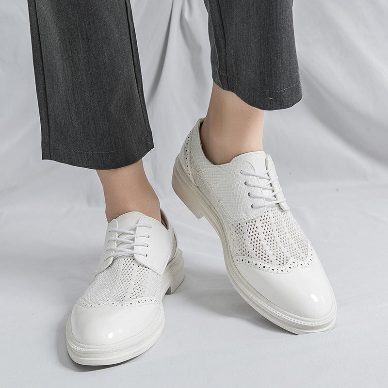 White sneakers worn with dark pants on a light gray background