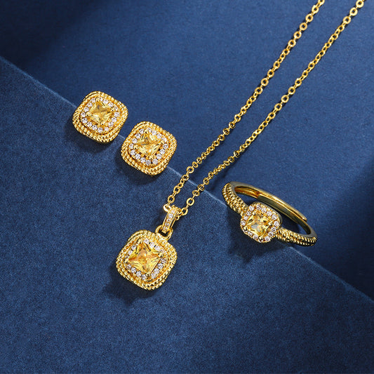 Gold jewelry set with necklace, ring, and earrings on a blue background