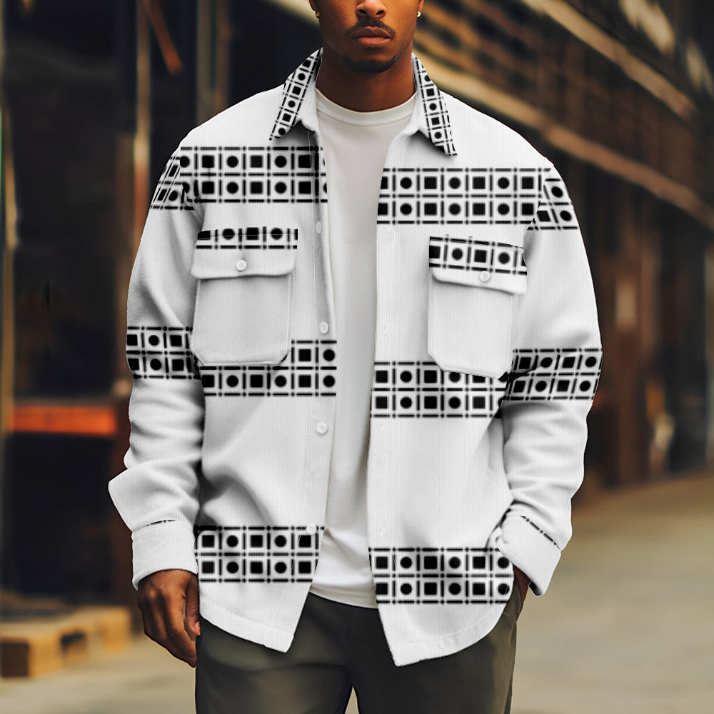 Person wearing a white shirt with black geometric patterns in an urban setting