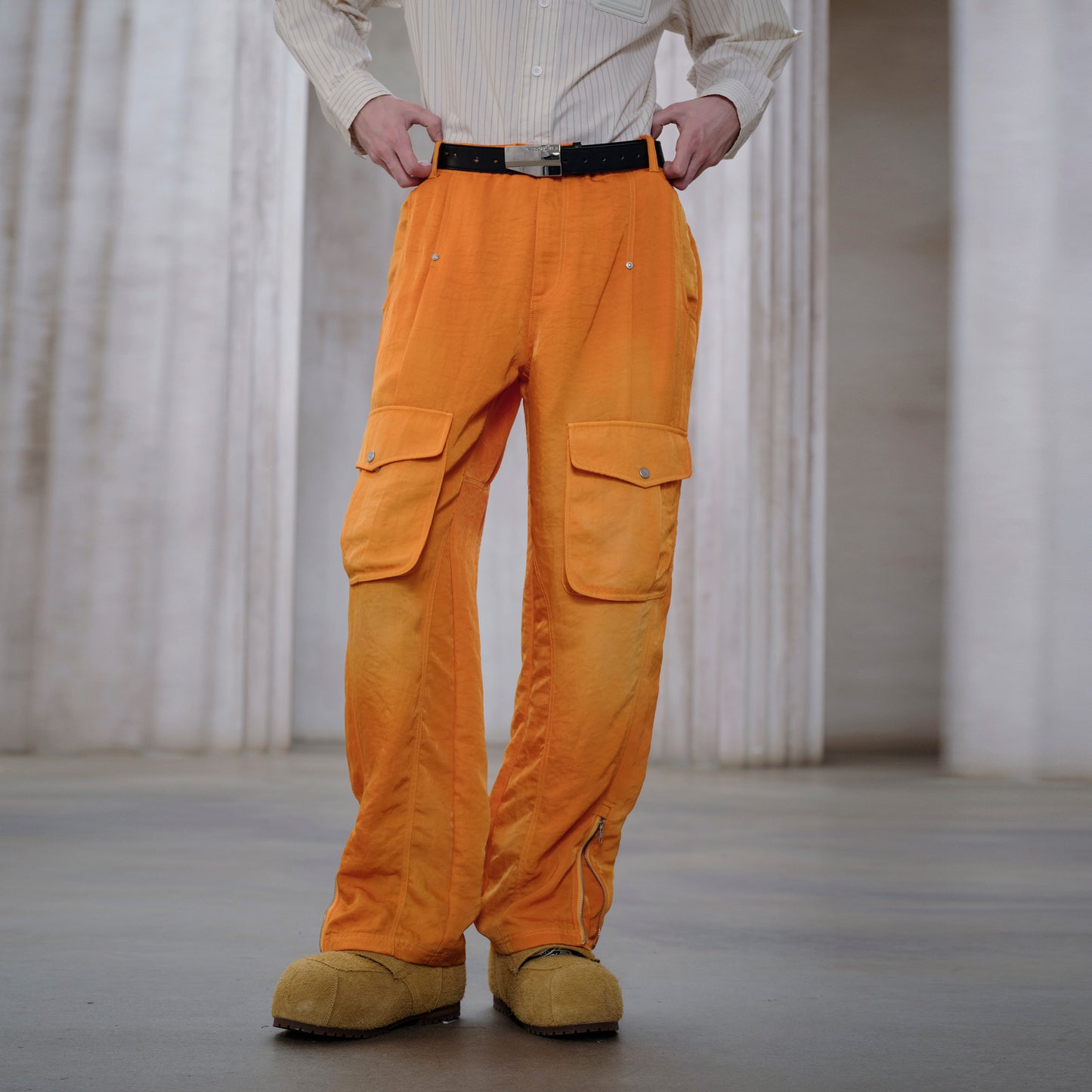 Person wearing orange cargo pants with a blurred background