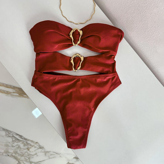 Red bikini with gold heart-shaped straps on a marble surface