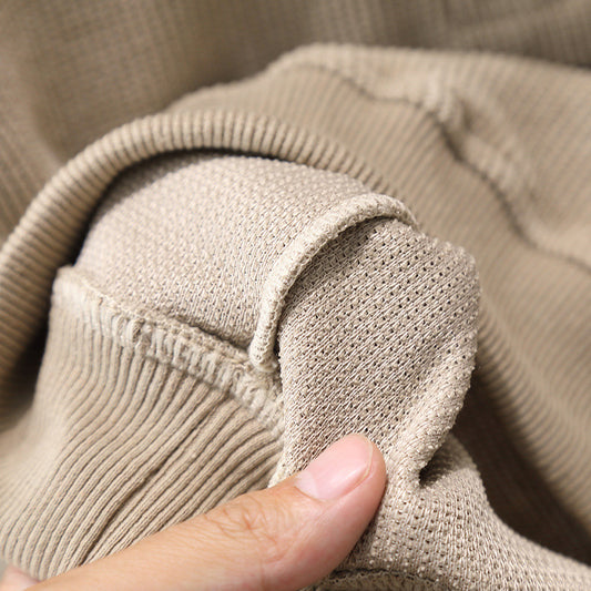 Close-up of beige fabric with a hand holding it