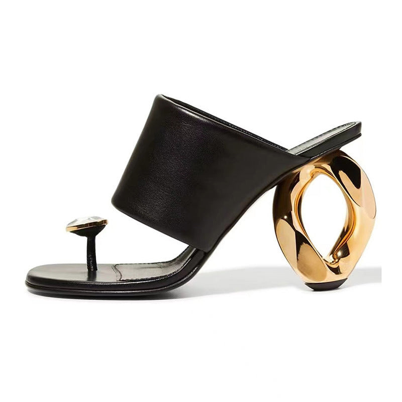 Black sandal with a gold heel on a white background