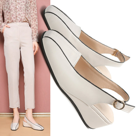 White wedge sandals with a woman wearing them against a pink wall.