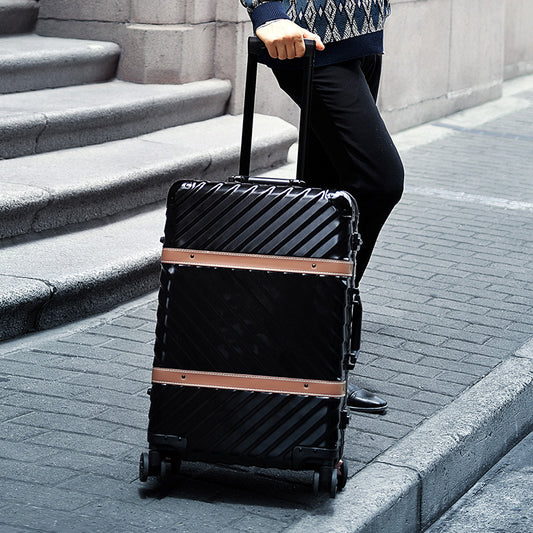 Person pulling a black suitcase with rose gold accents up a set of stairs.