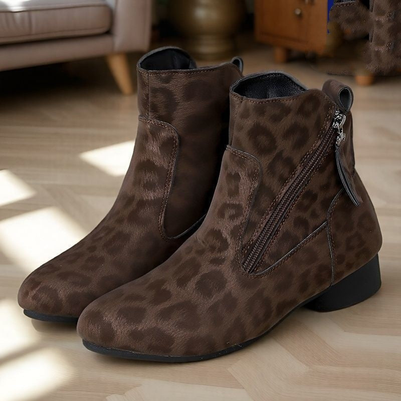 Brown leopard print ankle boots on a wooden floor