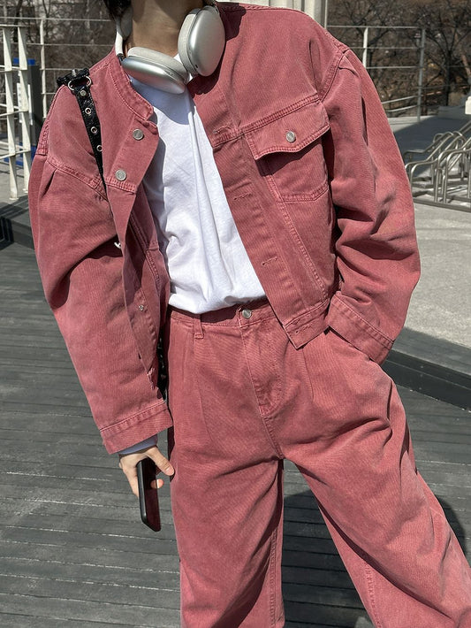 Person wearing a red jacket and pants standing on a wooden deck.