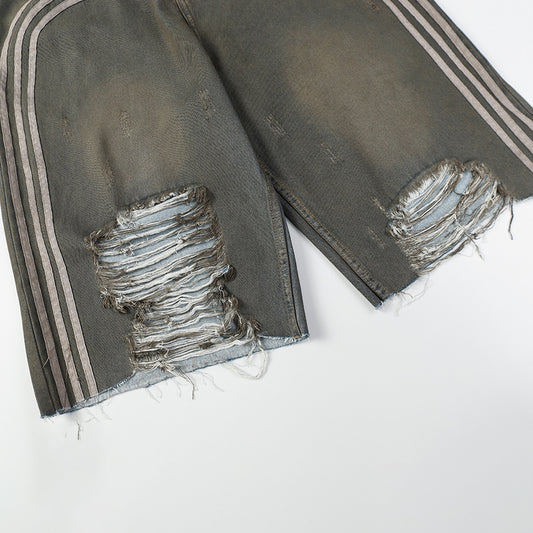 Distressed black jeans with white stripes on a white background