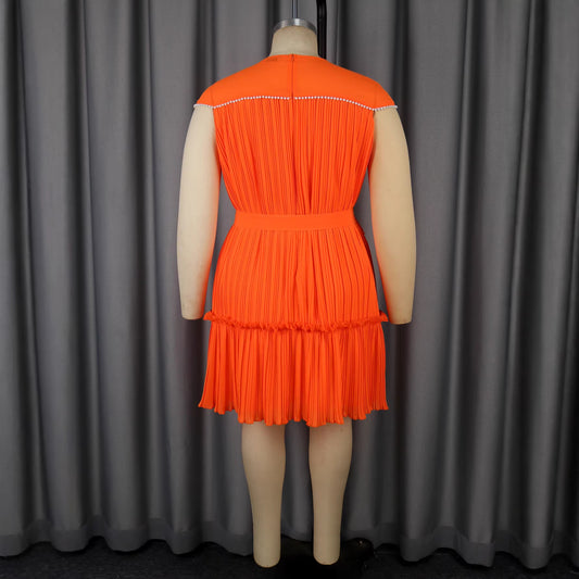 Orange pleated dress on a mannequin against a gray curtain background by millivan