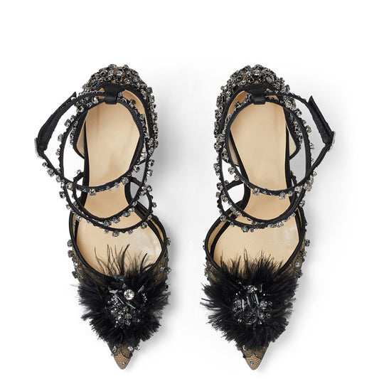 Black high-heeled shoes with feather details and crystal embellishments on a white background