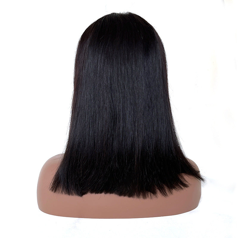 Black straight wig on a mannequin head against a white background