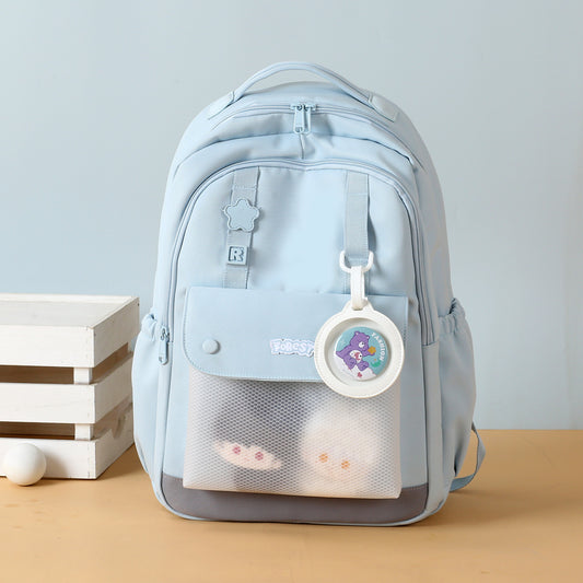 Light blue backpack with a clear front pocket on a beige surface.