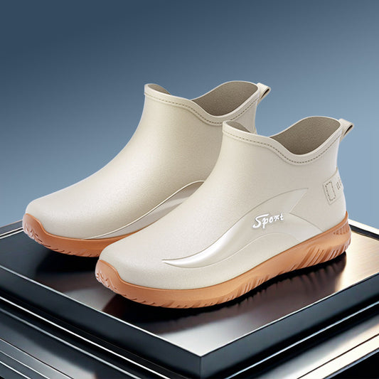 White rain boots with brown soles on a reflective surface