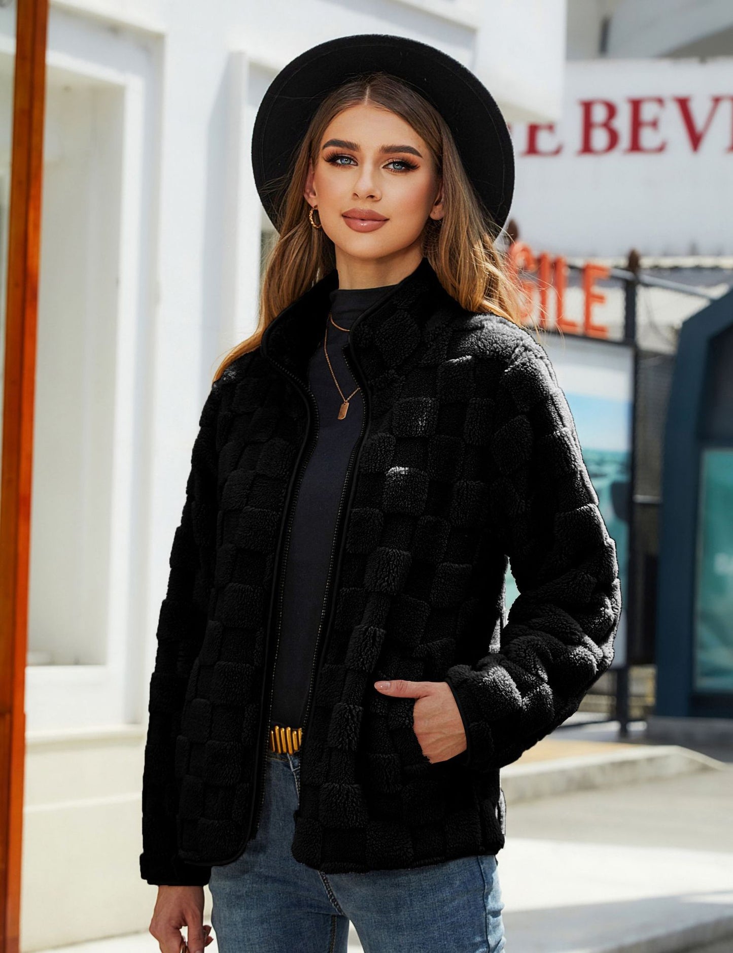 Woman wearing a black coat and hat in an urban setting