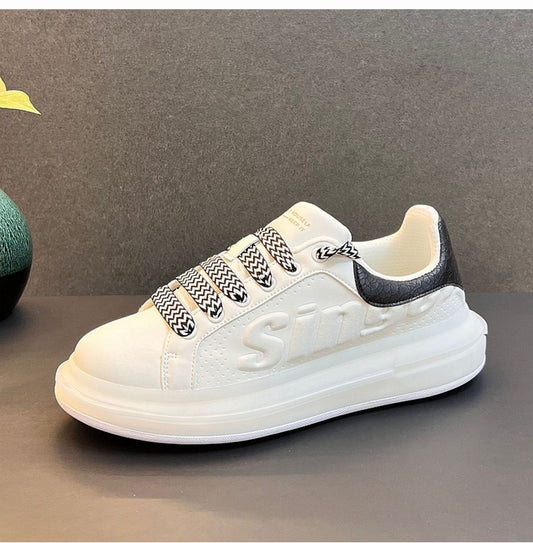 White sneaker with black accents on a gray surface