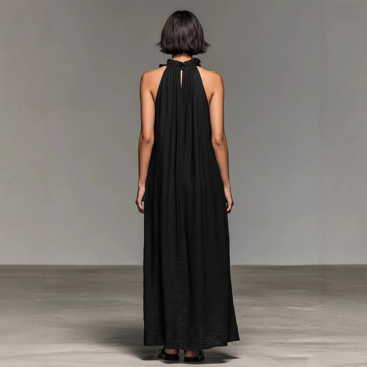 Woman wearing a black halter neck dress against a plain background by millivan