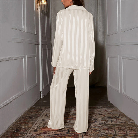 Person wearing a white striped pajama set in a room with gray walls and a patterned rug.