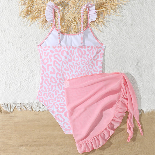 Pink leopard print swimsuit with matching cover-up on a textured surface