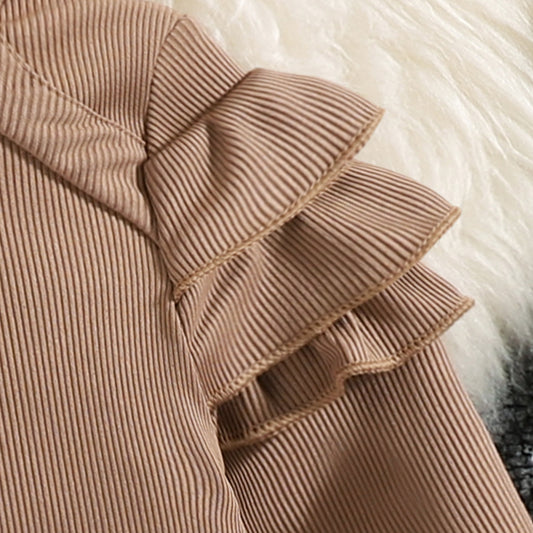 Close-up of a brown ribbed fabric with ruffled details on a fluffy white background