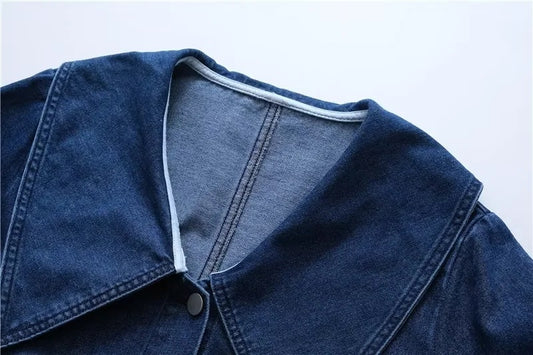 Close-up of a blue denim jacket on a light gray background