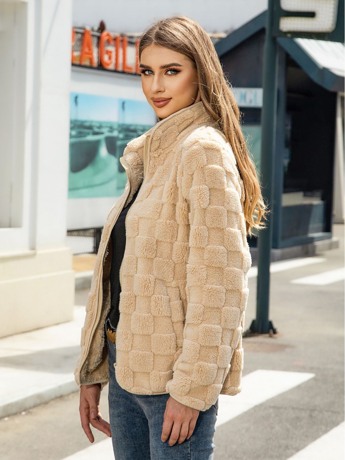 Woman wearing a beige quilted jacket outdoors with a blurred background
